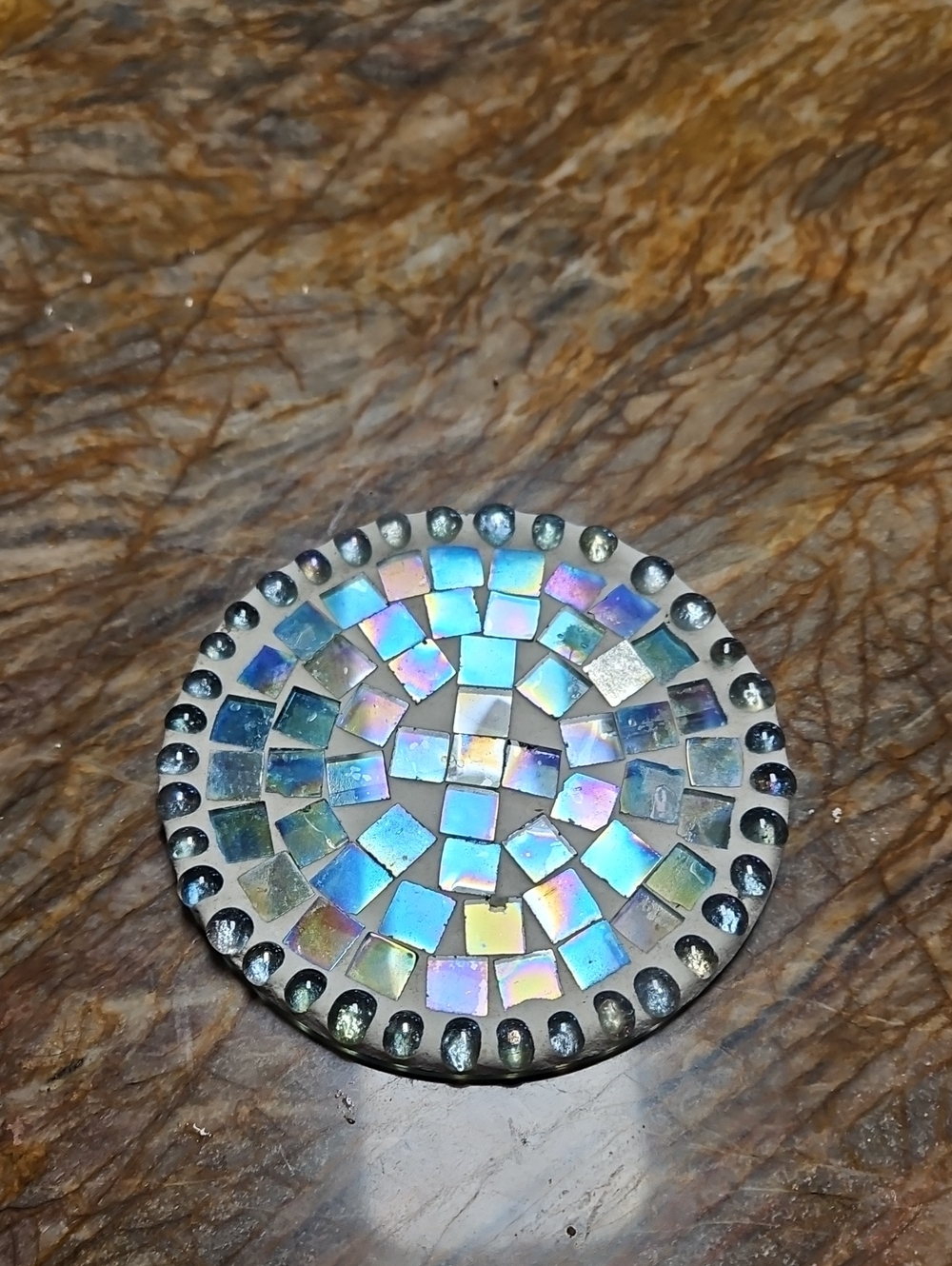 round mosaic coaster w/ iridescent, rainbow-hued glass tiles bordered by Beads